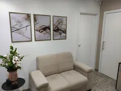 Sala de espera com sofá, quadros e flores